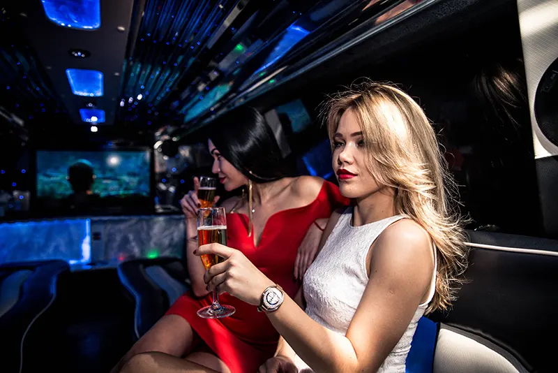 Women enjoying champagne in luxury limousine